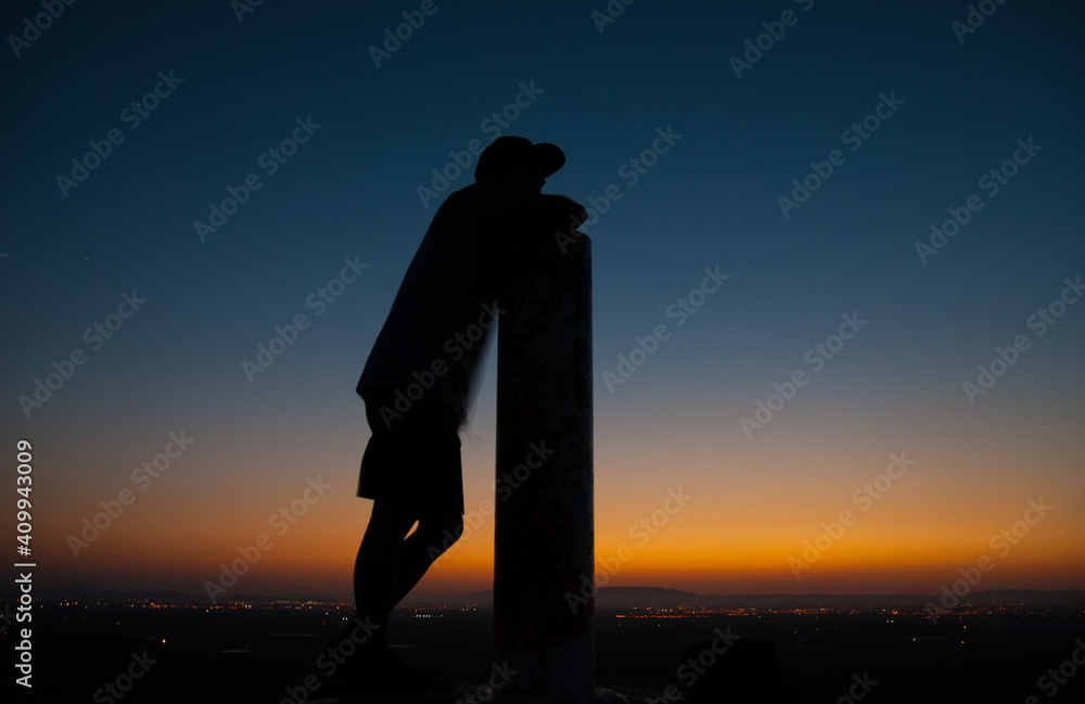 Sunset colors in the sky and a silhouette of a boy