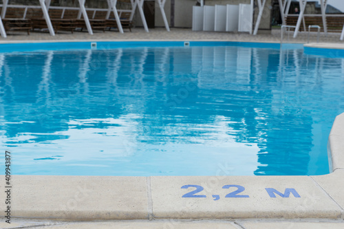 signs of depth in meters in swimming pool, deep pool with blue water, no people around, safety on water