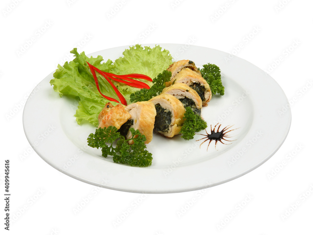 Close up of filled chicken fillet with spinach on white round plate Close up of filled chicken fillet with spinach on white round plate