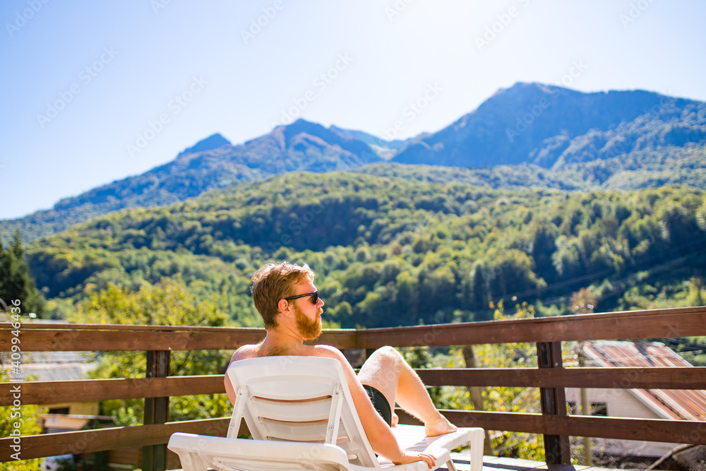 man in the pool looking at mountain landscape.Enjoying beautiful mountains