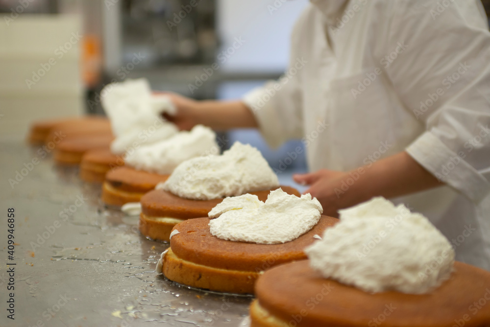 pastry chef while preparing cakes in a bakery workshop, focus selected
