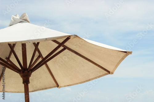 white linen beach parasol in blue sky 