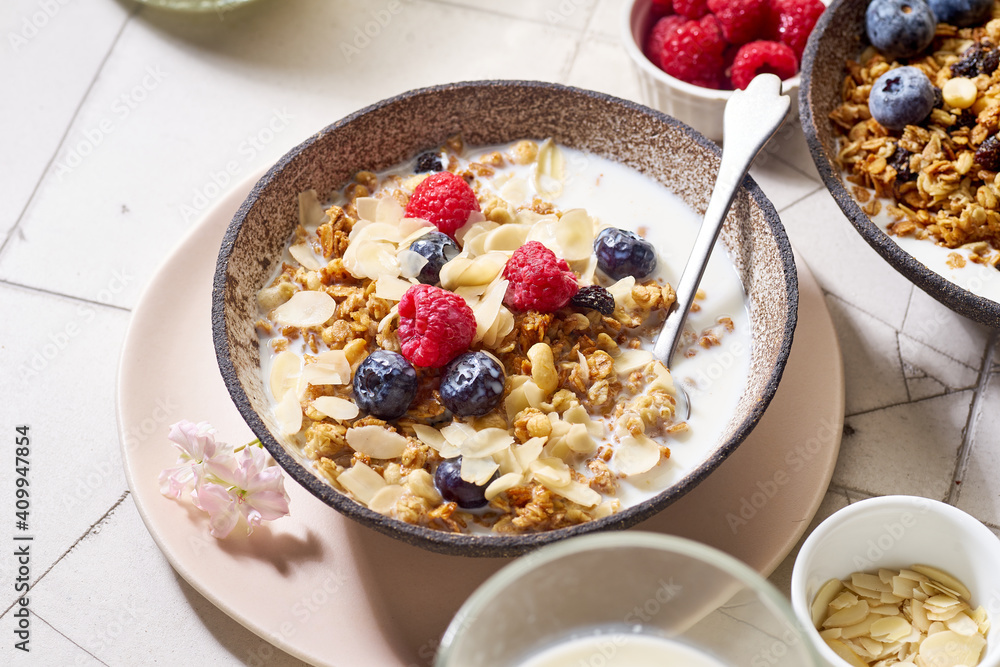 A bowl of granola with nuts and oats served with berries and milk A bowl of granola with nuts and oats served with berries and milk