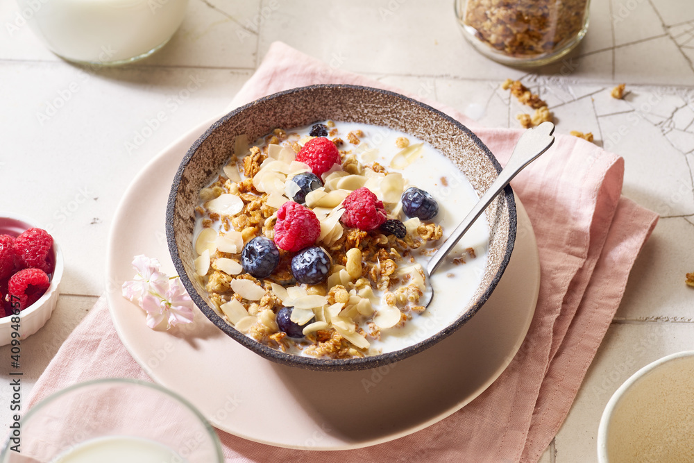 Flat lay with a bowl of granola with nuts and oats served with berries and milk Flat lay with a bowl of granola with nuts and oats served with berries and milk