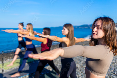 unity group of women practic yoga on rhe beach in morning © yurakrasil