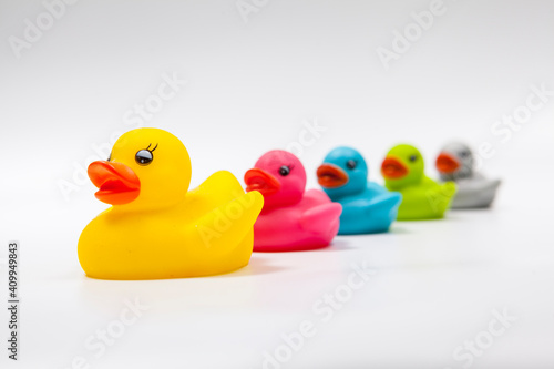 Obraz na plátně Bigger yellow rubber duck leading row of multicolored rubber ducks