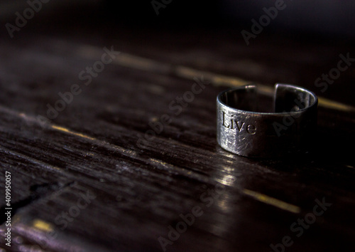 A silver ring with an inscription on a dark background. Life. High quality photo