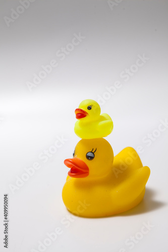 Mama rubber duck and her duckling on her head isolated