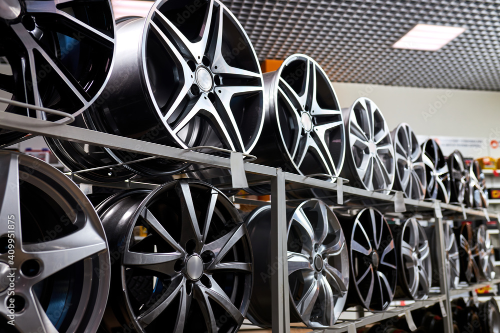 stand with alloy wheels in modern tire store, close up photo of auto wheels in auto service shop stand with alloy wheels in modern tire store, close up photo of auto wheels in auto service shop