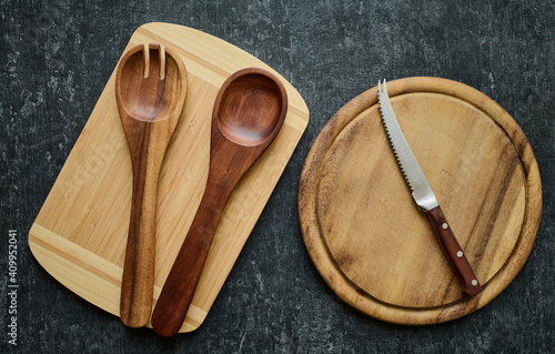 Wooden spoons and tomato knife on cutting boards, top view