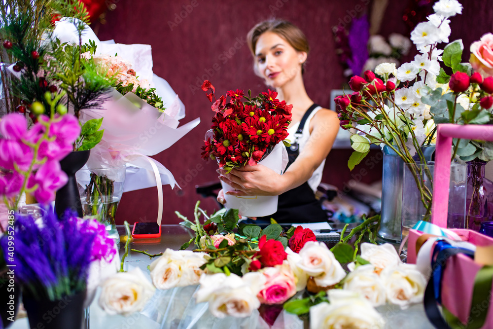 graceful blonde woman in apron selling a flowers in her store own graceful blonde woman in apron selling a flowers in her store own