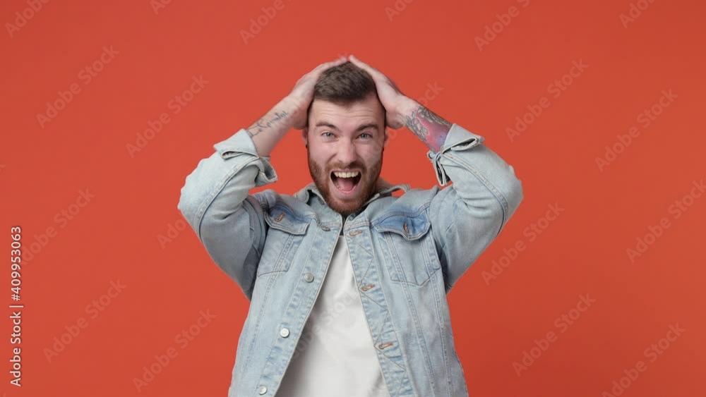 Excited joyful bearded young man 20s in t-shirt denim jacket isolated on orange background in studio. People lifestyle concept. Count countdown 1 2 3 one two three doing winner gesture spreading hands Excited joyful bearded young man 20s in t-shirt denim jacket isolated on orange background in studio. People lifestyle concept. Count countdown 1 2 3 one two three doing winner gesture spreading hands