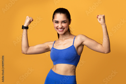 Happy sporty woman celebrating success gesturing at studio