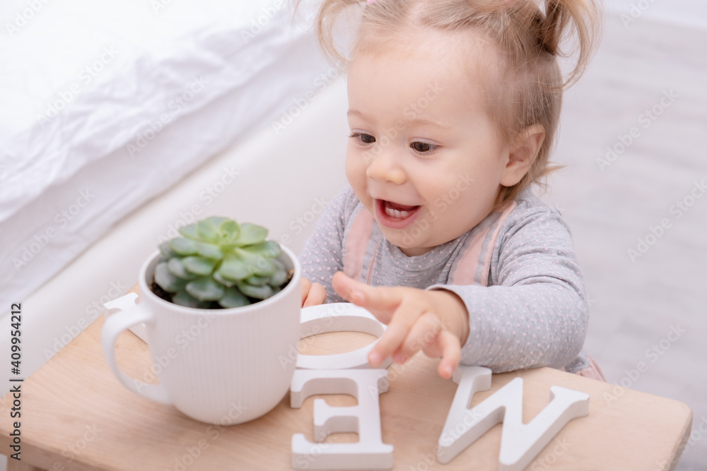 funny little girl carefully touches succulent in pot. funny little girl carefully touches succulent in pot.