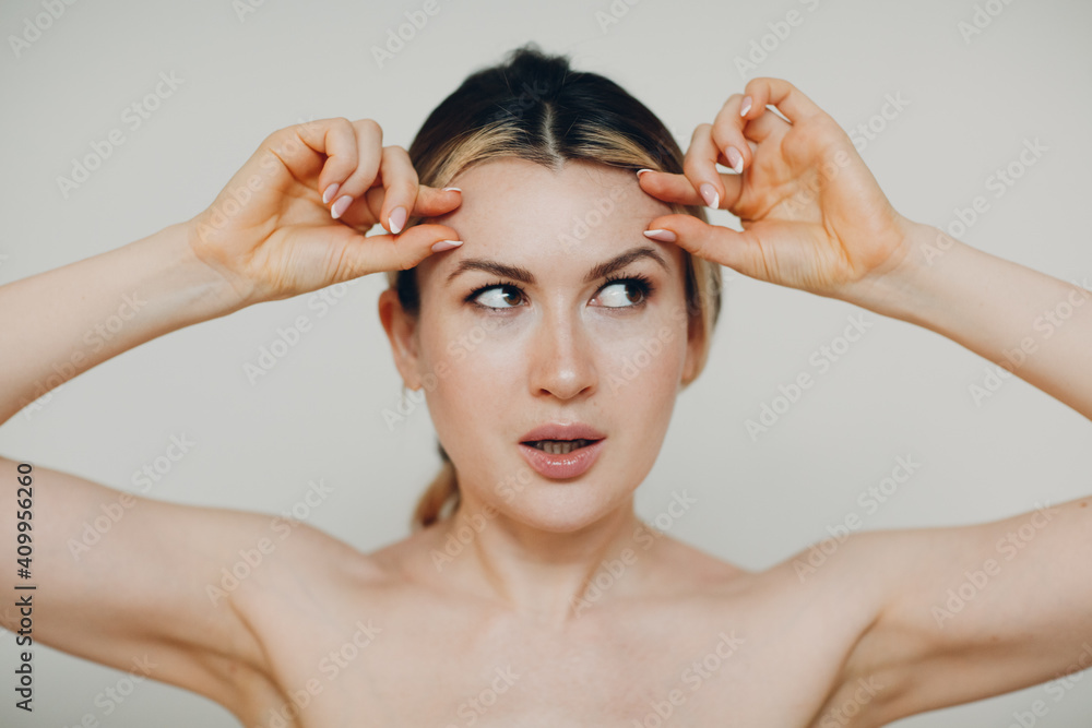 Fototapeta premium Young adult doing facial gymnastics self massage and rejuvenating exercises face building for skin and muscles lifting