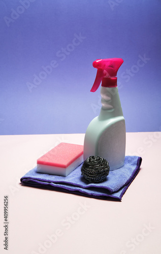 Top view of spray detergent arranged on pink and blue background with sponges and rag for cleaning concept photo