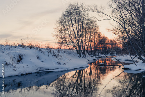 A beautiful sunset is reflected in the water surface of a quiet river