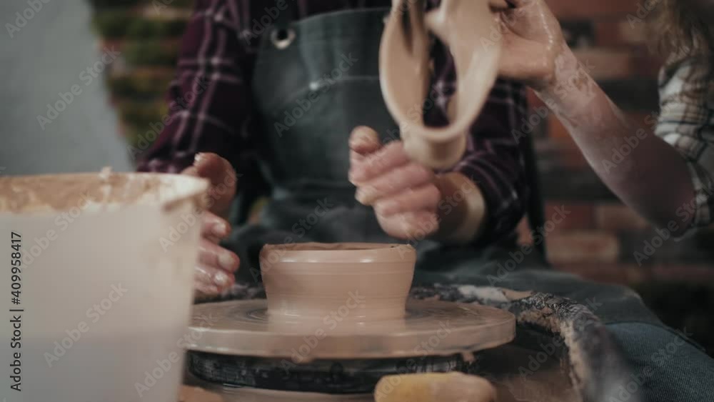 Potter masterclass, Man and woman are working with pottery wheel making pots during master class for adults, creative craftsman hobby. DIY Leisure activities and craftsmanship concept. Potter masterclass, Man and woman are working with pottery wheel making pots during master class for adults, creative craftsman hobby. DIY Leisure activities and craftsmanship concept.