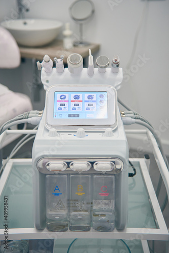 Contemporary dermabrasion machine for skin care treatment placed in bright room in beauty clinic photo