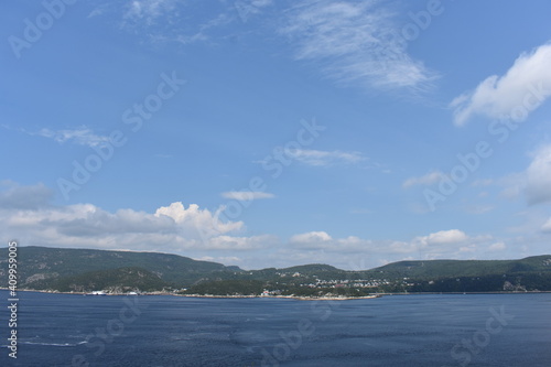 land and mounatins across the blue ocean on a summer day