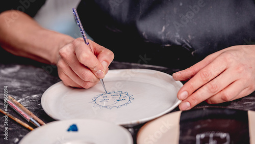 Woman drawing creative pattern on plate