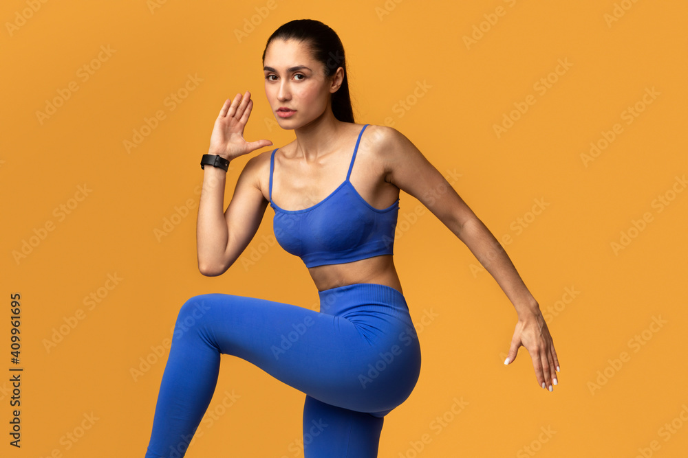 Young Woman Running And Exercising Isolated On Orange Background Young Woman Running And Exercising Isolated On Orange Background