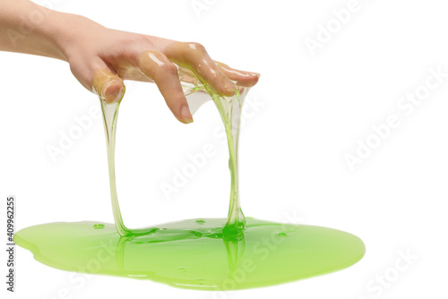 Green slime toy in woman hand isolated on white background.