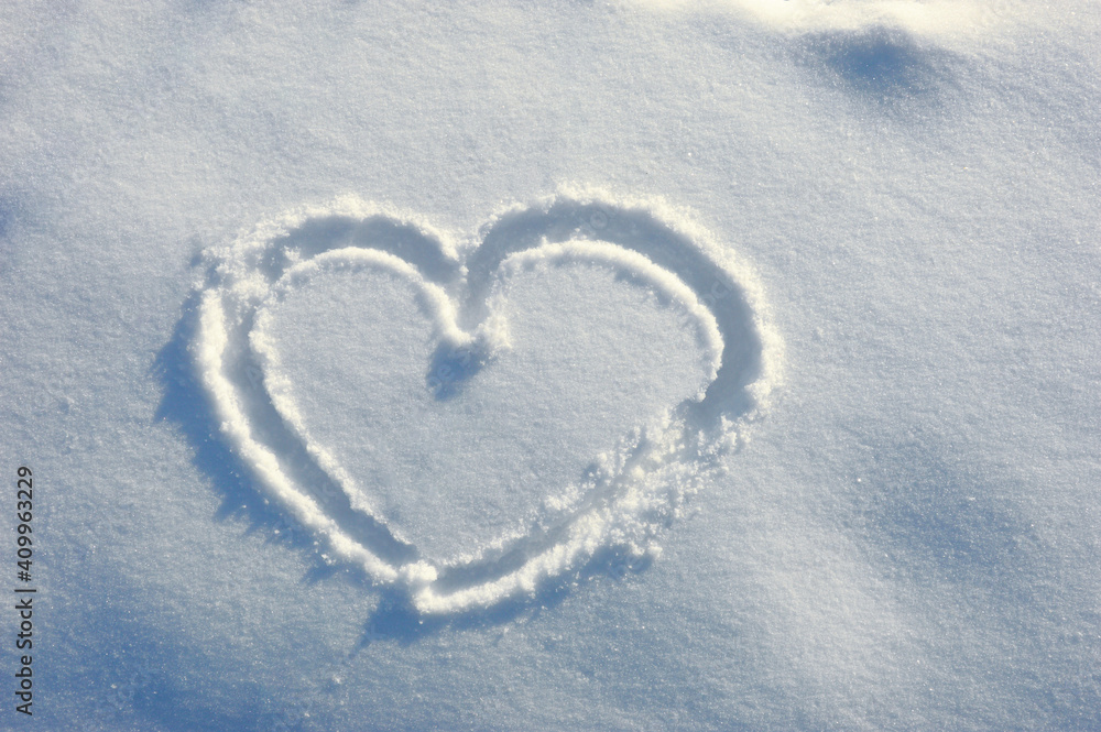 Heart in the snow. background for decoration for the holiday of Valentine's Day. Cold heart, love. white snow in winter, romance.