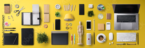 Flat lay top view office desk working space with laptop and supplies on yellow background. photo