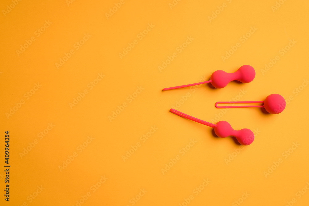 Red bright anal balls or butt plugs on an orange background with space for text. Sex toys for orgasm, masturbation. Flat Lay Red bright anal balls or butt plugs on an orange background with space for text. Sex toys for orgasm, masturbation. Flat Lay