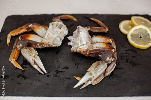 Raw, cleaned, uncooked Dungeness crab legs sit on a platter in the kitchen ready to be cooked for dinner photo