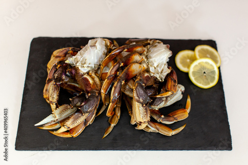 Raw, cleaned, uncooked Dungeness crab legs sit on a platter in the kitchen ready to be cooked for dinner photo