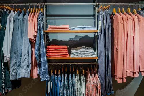 Interior detail of a modern clothing store with hanging clothes photo