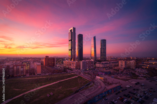 Cuatro Torres Business Area with skyscrapers reflecting bright sundown light in evening in Madrid photo