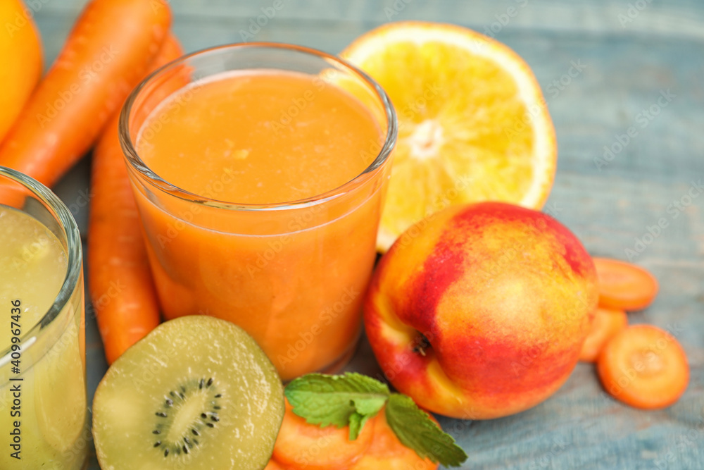 Glasses of delicious juices and fresh ingredients on light blue table, closeup Glasses of delicious juices and fresh ingredients on light blue table, closeup