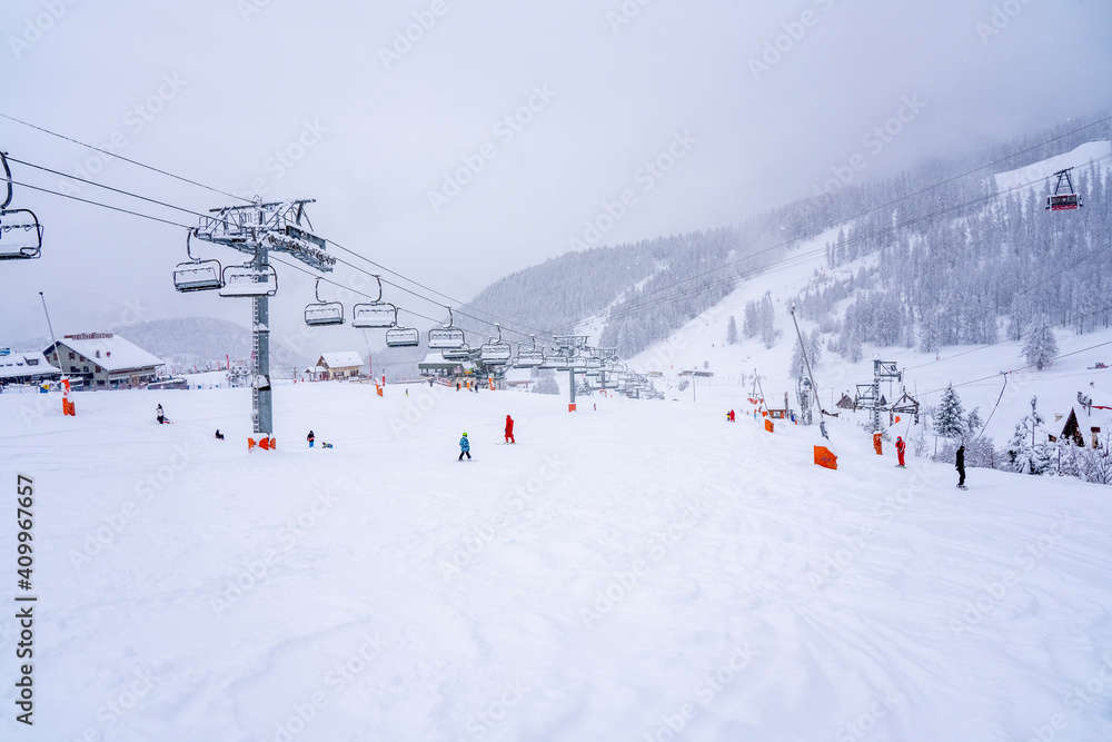 Auron, France - 01.01.2021: Downhill skiing during a heavy snowfall. Professional ski instructors and children on a resort slope in mountains. Blurred focus background. High quality photo Auron, France - 01.01.2021: Downhill skiing during a heavy snowfall. Professional ski instructors and children on a resort slope in mountains. Blurred focus background. High quality photo
