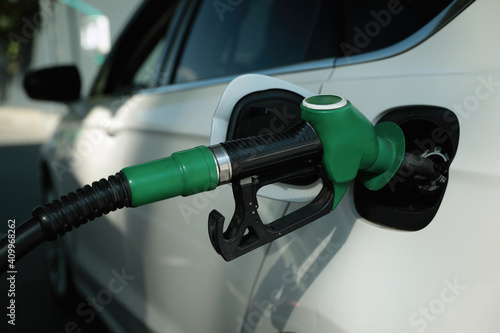 Refueling modern car with petrol pump on gas station, closeup