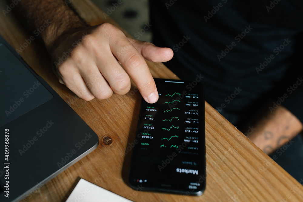 © Joy Zamora/ADDICTIVE STOCK - High angle of crop anonymous male entrepreneur using mobile app and working with diagrams at home © Joy Zamora/ADDICTIVE STOCK - High angle of crop anonymous male entrepreneur using mobile app and working with diagrams at home