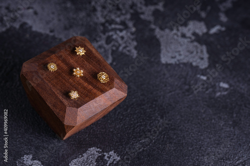 Beautiful piercing jewelry on wooden display. Macro shot. Selective focus. © kolidzei