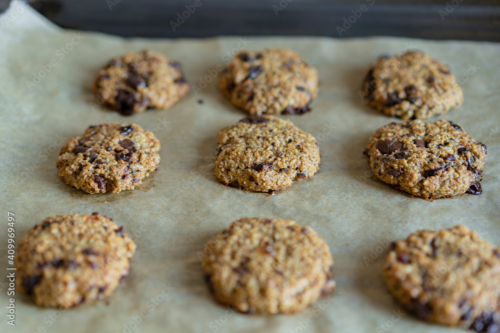Oatmeal cranberry round cookies before oven, homemade healthy vegan snack or biscuits. Homemade nut bars on baking sheet with ingredients for cooking on rustic table. Selective focus, copy space Oatmeal cranberry round cookies before oven, homemade healthy vegan snack or biscuits. Homemade nut bars on baking sheet with ingredients for cooking on rustic table. Selective focus, copy space