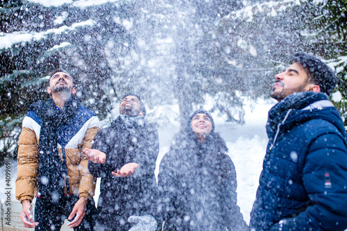 group of four indian having fun playing in snow outdoors spending Chrisymas holidays photo