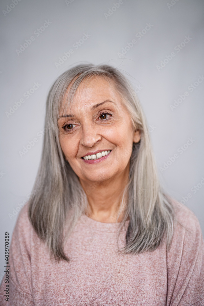 Front view portrait of happy senior woman standing indoors at home. Front view portrait of happy senior woman standing indoors at home.