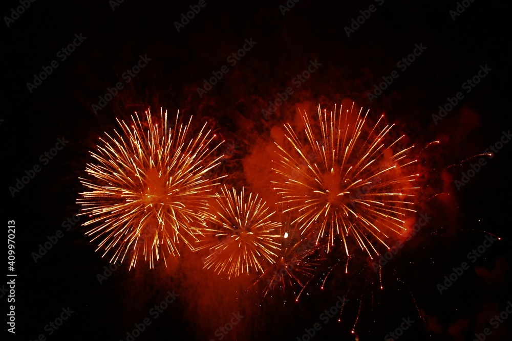 red and orange fireworks in the night sky