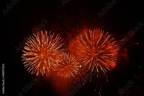 red and orange fireworks in the night sky