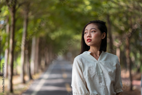 Ethnic Asian female walking in Tanya Shen Green Bikeway looking away