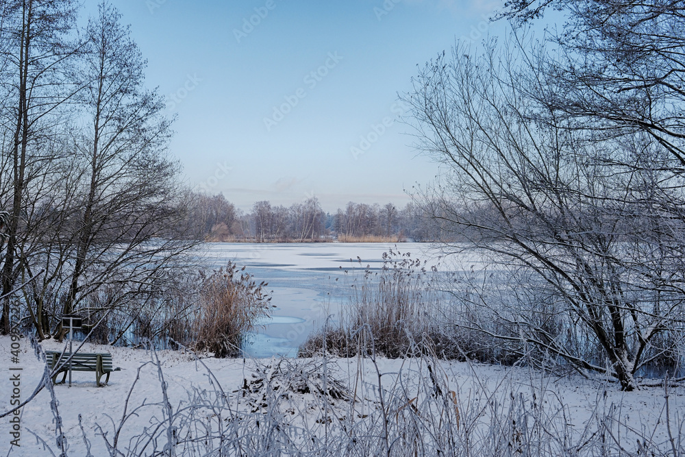 blick auf einen see im winter mit eis und schnee in schleswig holstein bei schönem wetter im naturpark lauenburgische seen, ort güster
