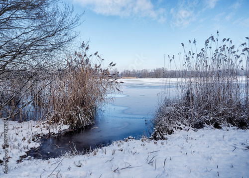 blick auf einen see im winter mit eis und schnee in schleswig holstein bei schönem wetter im naturpark lauenburgische seen, ort güster