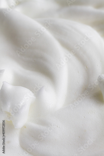 From above closeup of glass bowl with whipped eggs whites placed on table during food preparation