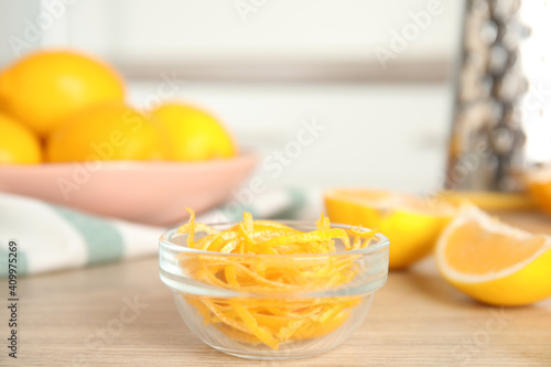 Grated lemon zest and fresh fruits on wooden table