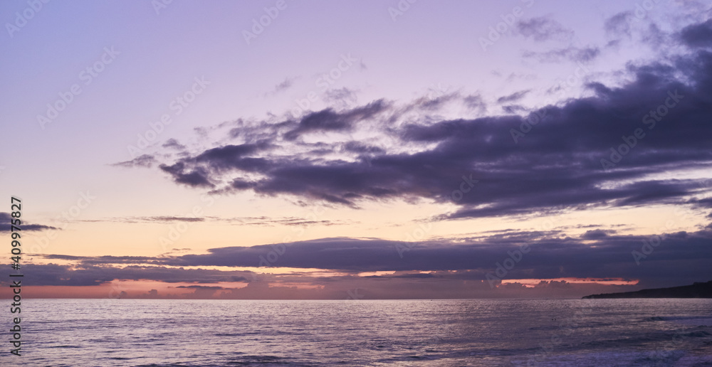 Amazing scenery of sunset over sea. Seascape at dusk in purple and pink tones